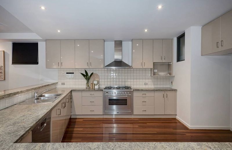Fully equipped kitchen with stone benches and timber floors
